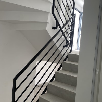 מעקה מתכת שחור על מדרגות בטון אפורות