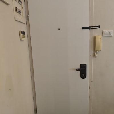 דלת לבנה עם ידית ומנעול שחורים