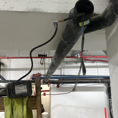 צינור שחור תלוי עם כבל וכלי עבודה