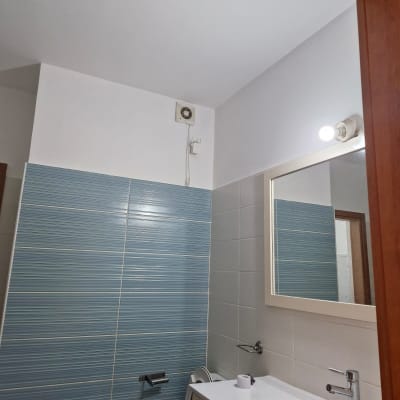 חדר אמבטיה עם אריחים כחולים וכיור לבן