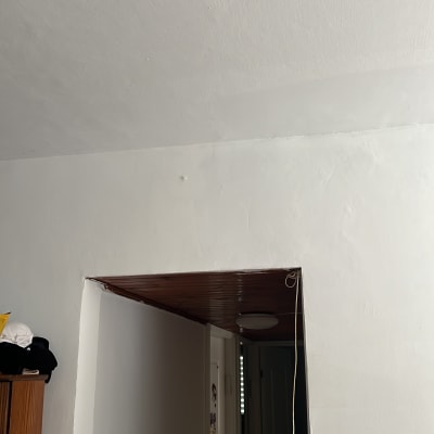 קיר ותקרה צבועים בלבן עם מרקם חלק