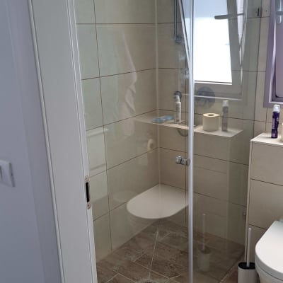 מקלחון זכוכית בחדר אמבטיה עם רצפת אריחים