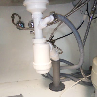 צנרת מתחת לכיור עם צינורות ואביזרי חיבור