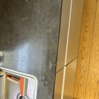 משטח שיש כהה ליד כיור עם ברז כתום