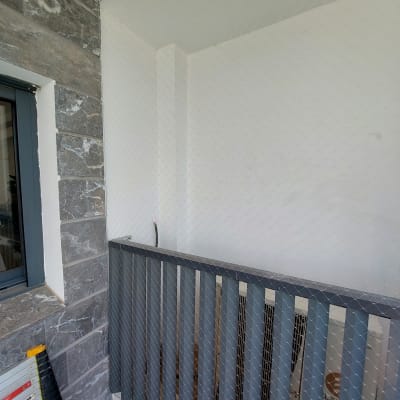 רשת יונים מותקנת על מרפסת למניעת כניסת יונים