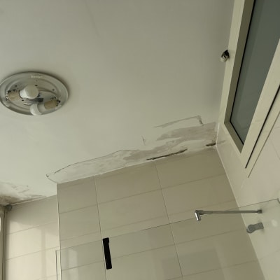 תקרה עם תיקוני צבע ליד חלון ומנורה