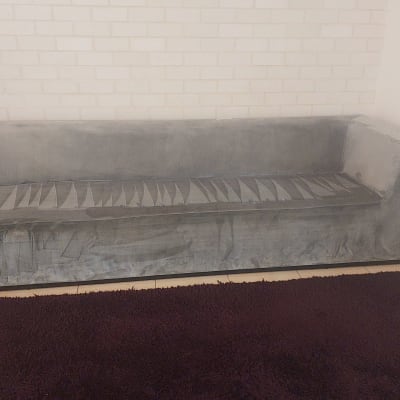 ספה אפורה עם כתמי לכלוך נראים לעין