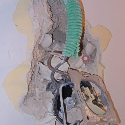 שקע חשמלי פתוח עם חוטים וצינור ירוק