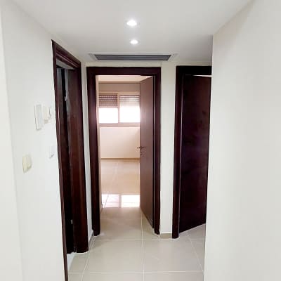 קירות גבס לבנים עם תאורה שקועה בתקרה