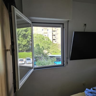 חלון אלומיניום פתוח עם נוף חיצוני