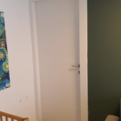 דלת לבנה עם ידית מתכת בחדר