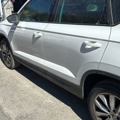 מכונית לבנה עם דלתות צד וחישוקי גלגלים