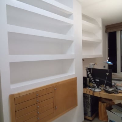 מדפים לבנים צבועים על קיר עם ארון עץ