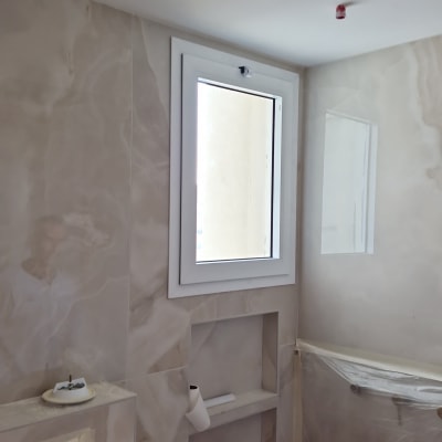 חלון אלומיניום לבן מותקן בקיר חדר אמבטיה