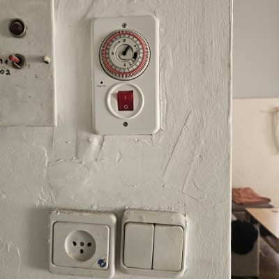 שעון טיימר ומתג להפעלת דוד שמש על קיר לבן