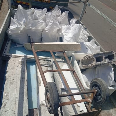 עגלה עם שקי פסולת וחומרי בניין על עגלה פתוחה