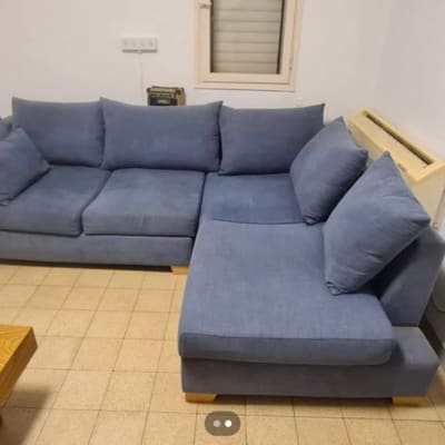 ספה פינתית כחולה בחדר עם רצפת אריחים