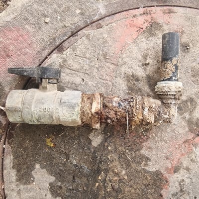 ברז מים ישן וחלוד על רקע בטון