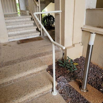 מעקה מתכת ליד מדרגות בכניסה לבניין