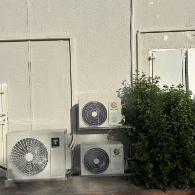 שלוש יחידות חיצוניות של מזגנים מותקנות על קיר חיצוני