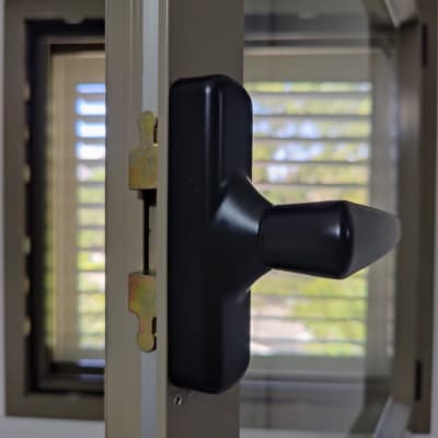 ידית חלון עם תריסים ברקע