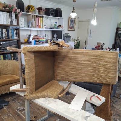 רהיט בתהליך ריפוד בסדנה עם כלים וחומרים