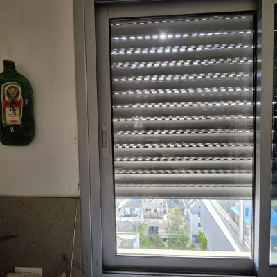 חלון עם תריסים נוף עירוני ברקע