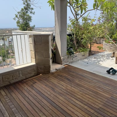 מרפסת עץ עם צמחים וכלי עבודה לגינה