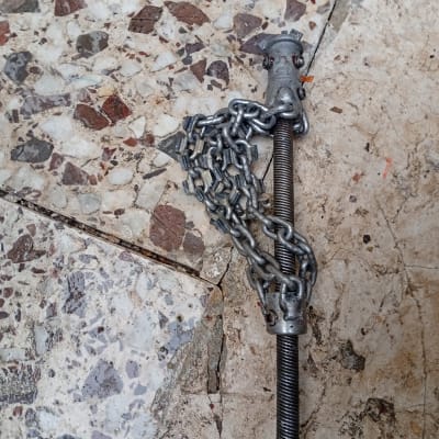 שרשרת מתכת מחוברת לצינור על רצפה