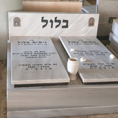 שני מצבות עם כיתוב בעברית ואבנים קטנות