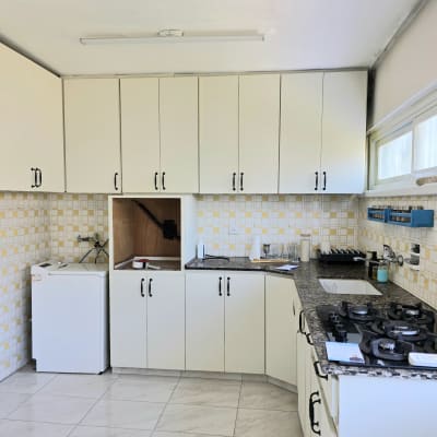 מטבח עם ארונות לבנים וכיריים גז