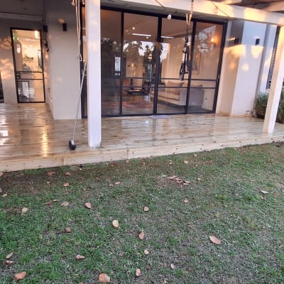 דק עץ חדש עם שולחן בחצר בית