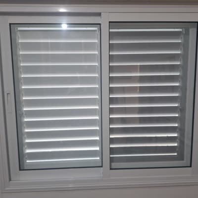 חלון אלומיניום עם תריסים לבנים