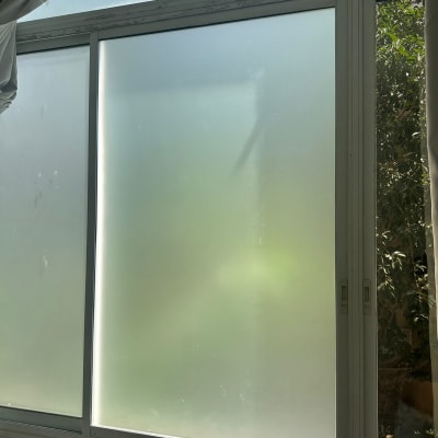 חלון זכוכית חלבית עם מסגרת מתכת לבנה