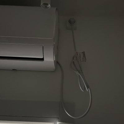 מזגן מותקן על קיר עם חוטי חשמל