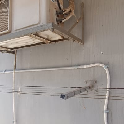 יחידת מיזוג אוויר מותקנת על קיר עם חיווט חשמלי גלוי