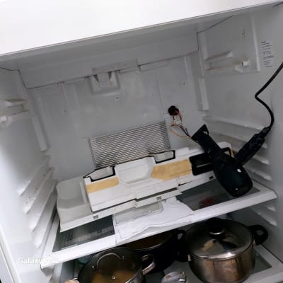 מייבש שיער בתוך מקרר פתוח עם חלקים חשופים