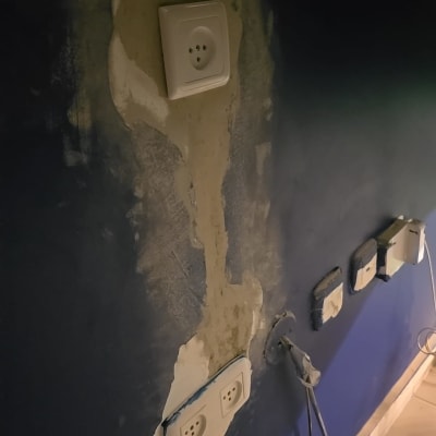 שקעים חשמליים בקיר עם חוטים חשופים