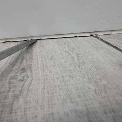 כלים בודקים סדק ברצפה ליד קיר רטוב