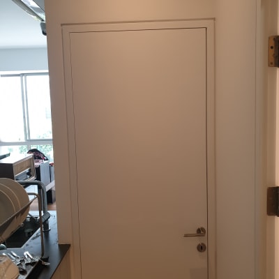 דלת לבנה עם ידית מתכת בחדר מואר