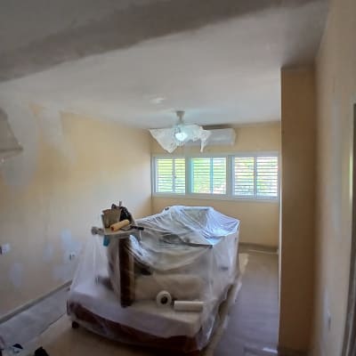 חדר עם רהיטים מכוסים בניילון וכלי צביעה