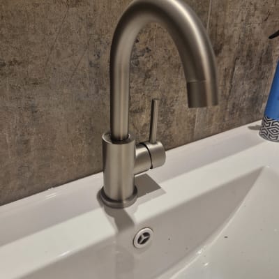 ברז כיור מתכת מותקן על קיר אריחים