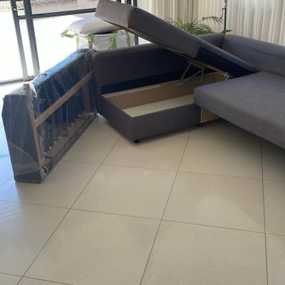 ספה מפורקת ליד חלון עם וילונות