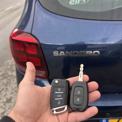 מפתחות רכב מול רכב כחול עם לוחית רישוי ישראלית