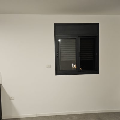 קיר צבוע בלבן עם חלון שחור