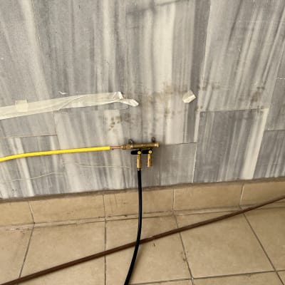 צינור גז צהוב מחובר לשסתום על קיר