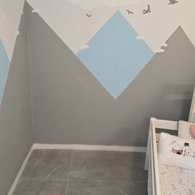 קיר צבוע בציורי הרים, עננים וציפורים