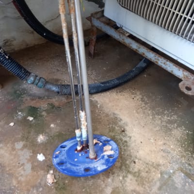 חלקי מתכת חלודים ליד מערכת מיזוג אוויר