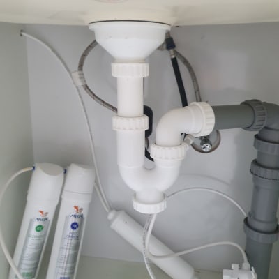 צנרת מתחת לכיור עם מסנני מים
