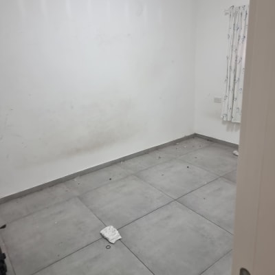 חדר ריק עם קירות לבנים ורצפת אריחים אפורה